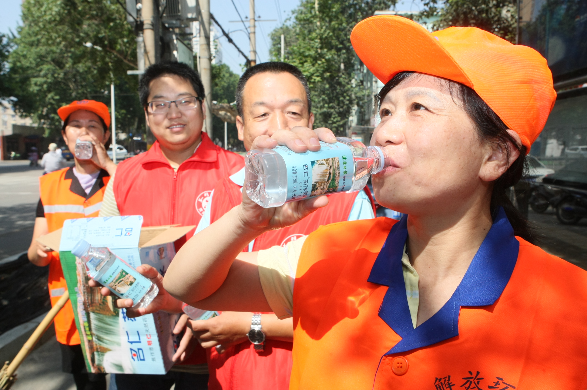 图二,图三:6月11日,解放区环卫工人高兴地在一起喝水.