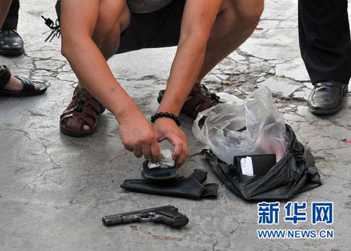 8月14日,警方在犯罪嫌疑人周克华被击毙现场清理其所持枪械等物品。当日6时50分，在公安部统一指挥下，经过重庆等地公安机关连续数日艰苦奋战，犯下累累罪行的公安部Ａ级通缉犯周克华在重庆沙坪坝区童家桥被公安民警成功击毙。至此，苏湘渝系列持枪抢劫杀人案件成功告破。新华社发（公安部提供）图片来源：新华网